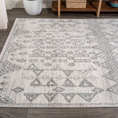 an area rug with grey and white designs on it