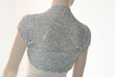 a mannequin wearing a silver dress with beading on it