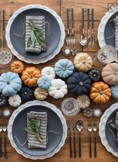 the table is set with pumpkins, silverware and other decorative items on it