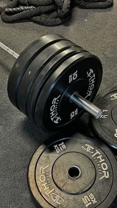 two weight plates and one barbell on the ground