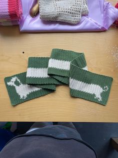 several knitted items sitting on top of a wooden table