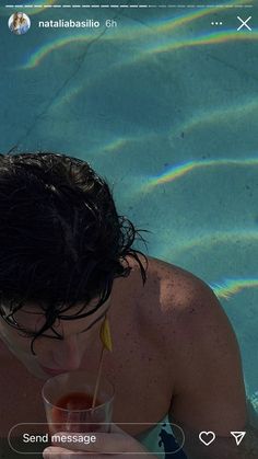 a man in the water drinking from a straw cup with a straw sticking out of it