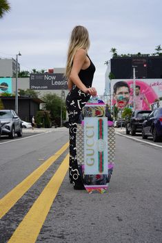 a woman is holding a skateboard on the street