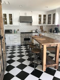 a black and white checkered floor in a kitchen with stools on the counter