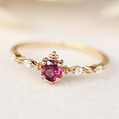 a gold ring with a pink stone in the middle