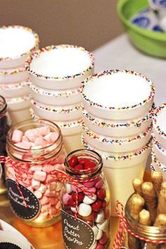 a table topped with lots of jars filled with candy