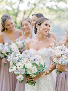 a group of women standing next to each other holding bouquets