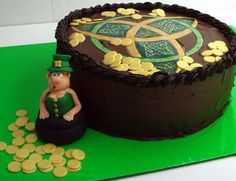 a cake decorated with gold coins and a leprechaun sitting next to it