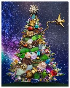 a colorful christmas tree with ornaments on it's top and an ornament hanging from the bottom