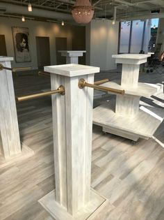 two white marble pedestals with gold handles in an office building, one is empty and the other has no people