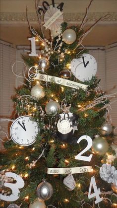 a small christmas tree decorated with clocks and ribbons