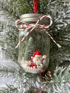 a mason jar ornament hanging from a christmas tree filled with candy canes