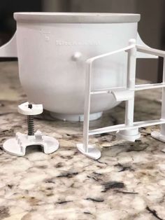 a large white bowl sitting on top of a counter next to a screwdriver