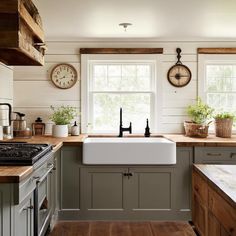 A farmhouse kitchen featuring shiplap walls, a large apron sink, rustic wooden countertops, and vintage decor elements, creating a warm, cozy, and inviting kitchen design full of rustic charm. Shiplap Backsplash Kitchen Butcher Block, Grey Green Kitchen Cabinets With Butcher Block, Shiplap Wall Kitchen Farmhouse, Kitchens With Shiplap Walls, Vintage Sink Kitchen, Shiplap Wall In Kitchen, Farmhouse Kitchen Butcher Block Counters, Farmhouse Sink Butcher Block Countertops, Butcher Block Countertops Backsplash