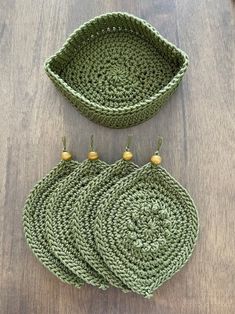 two crocheted baskets sitting on top of a wooden table