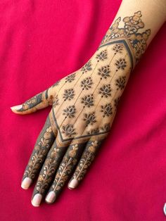 a woman's hand with henna tattoos on it