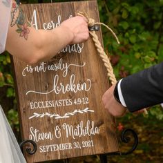 the bride and groom are getting ready to put their wedding date on a wooden sign