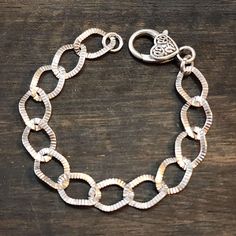 "This is an amazing, silver tone chain bracelet. The links are textured on one side and smooth on the other. Links are \"twist\" style which helps the bracelet lay flat.  This artisan jewelry has a rustic charm that will add a touch of Boho style to any outfit. This chain bracelet is the perfect accessory for any occasion. It is lightweight and comfortable to wear, so you can enjoy it all day long.  Whether you're looking to make a bold fashion statement or simply add a touch of natural beauty t Chunky Silver Bracelet, Twist Style, Bracelet Handmade, Bold Fashion, Chain Link Bracelet, Artisan Jewelry, Rustic Charm, Handmade Bracelets, Link Bracelets