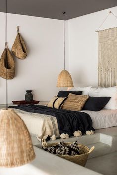 a bedroom with wicker lamps hanging from the ceiling and a bed in the middle