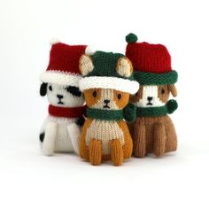 three knitted dogs wearing hats and scarves