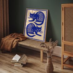 a blue and white painting sitting on top of a wooden bench next to a vase