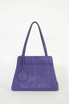 BOUSIINNE violet shoulder handbag made of suede leather. Model with magnetic clasp closure, double handle, with inside and outside pockets and a charm with the logo. Interior with camel cotton canvas lining. Handcrafted. Made in Spain. Details Dimensions: 23 cm high x 31 cm wide x 11 cm deep Handle: 24 cm high Semi-rigid design Customised interior with the label featuring the logo Includes BOUSIINNE protective bag Fast Fashion Brands, Stylish Tote Bag, Suede Handbags, Tote Bags Handmade, How To Make Handbags, Shoulder Handbag, Magnetic Clasp, Bag Fashion, Shoulder Handbags