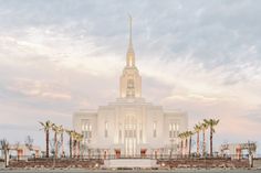 a large white church with palm trees in front