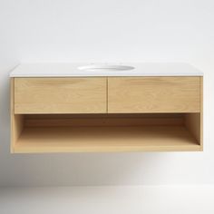 a bathroom sink sitting on top of a wooden cabinet next to a white countertop