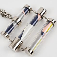 This stunning chunky Emilio Pucci chromed metal and silk necklace features a futuristic abstract shape with a heavy chrome chain and dimensional tube-shaped trio pendant. Emilio Pucci's signature silk abstract fabric is encased in resin or Lucite tubes. The necklace has a lobster closing clasp with a little chain for length flexibility. Emilio Pucci's hallmark is engraved on one of the tubes and reads Emilio Pucci - Made in Italy. Measurements: the necklace's total length is 22.83 in long (58 cm Modern Glass Chain Necklace, Abstract Fabric, Silk Necklace, Abstract Shape, Chrome Metal, Emilio Pucci, Abstract Shapes, Hallmark, Choker