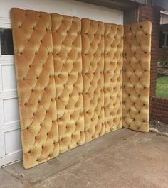 a wall made out of old mattresses in front of a garage with a white door