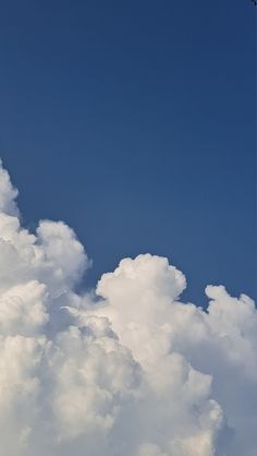 an airplane flying high in the sky with clouds around it and a jet plane above