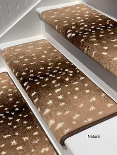 three brown and white rugs sitting on top of each other in front of a stair case