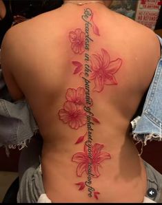 the back of a woman's body with pink flowers on it and an inscription that reads