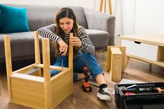 a woman sitting on the floor with tools in front of her