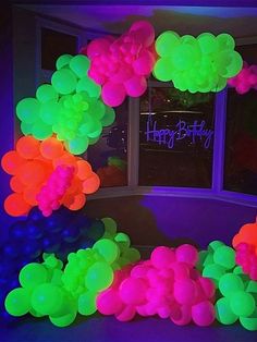 balloons are arranged in the shape of a wreath on a window sill at night