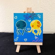 an octopus and jellyfish painting on a small easel