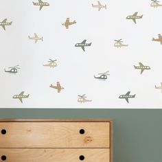 an airplane wall decal is on the wall next to a dresser