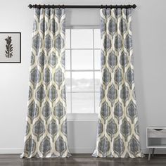 the curtains in this room are decorated with blue and white patterns, while the window curtain is