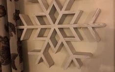 a snowflake made out of wood sitting on top of a window sill