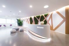 an office lobby with white walls and plants on the wall