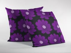 two purple flowers on black pillow cases sitting side by side in front of each other