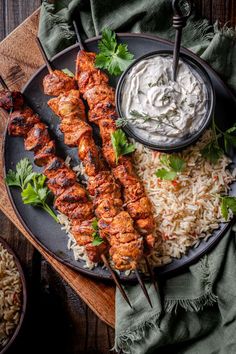 grilled chicken skewers with rice and cilantro sauce on a plate