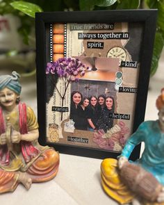 a couple of figurines sitting on top of a table next to a photo frame