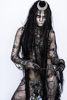 a woman with long black hair and tattoos on her body