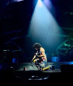 a man kneeling down on top of a stage