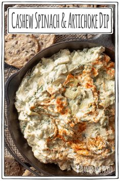 a bowl filled with spinach and artichoke dip on top of crackers