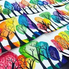 several colorful trees painted on white paper