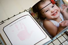 an open children's book with a photo of a baby on the cover and handprint