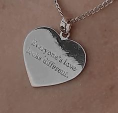 a heart shaped necklace with the words everyone's love looks different