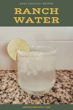 a glass filled with water sitting on top of a counter next to a lime slice